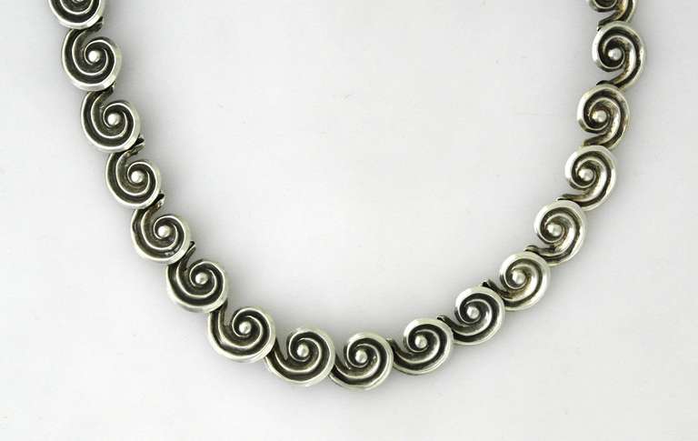 Being offered is a circa 1960s sterling silver necklace by Los Castillo of Taxco, Mexico, comprising swirl motif links; hook clasp. Dimensions 17 inches length. Marked as illustrated. In excellent condition.