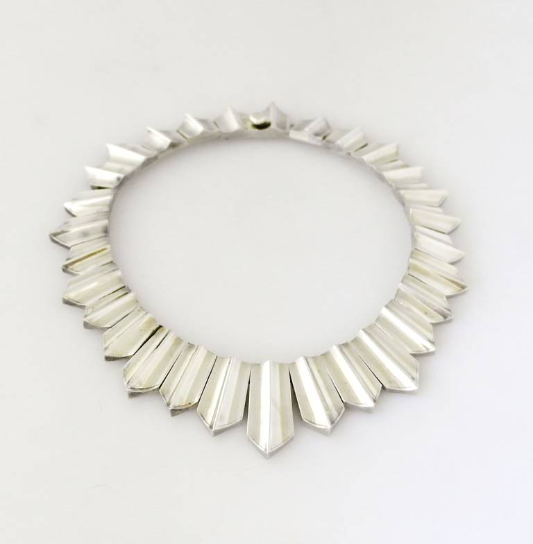 Being offered is a circa 1969 .970 silver necklace by Antonio Pineda of Taxco, Mexico, modernist solid collar in graduated sections, the longest link just under 1 1/2 inches long.  Dimensions 15 inches long.  Weight 163 grams.
Marked.  In excellent