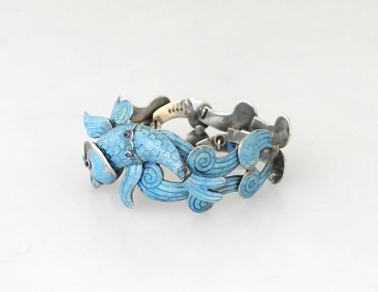Being offered is a circa 1960 bracelet by Margot de Taxco, the bracelet with blue enamel wave and fish design secured with box clasp and chain.  Length 7+ inches.  Weight 4 ozs.  Marked.  In excellent condition, all enamel intact.