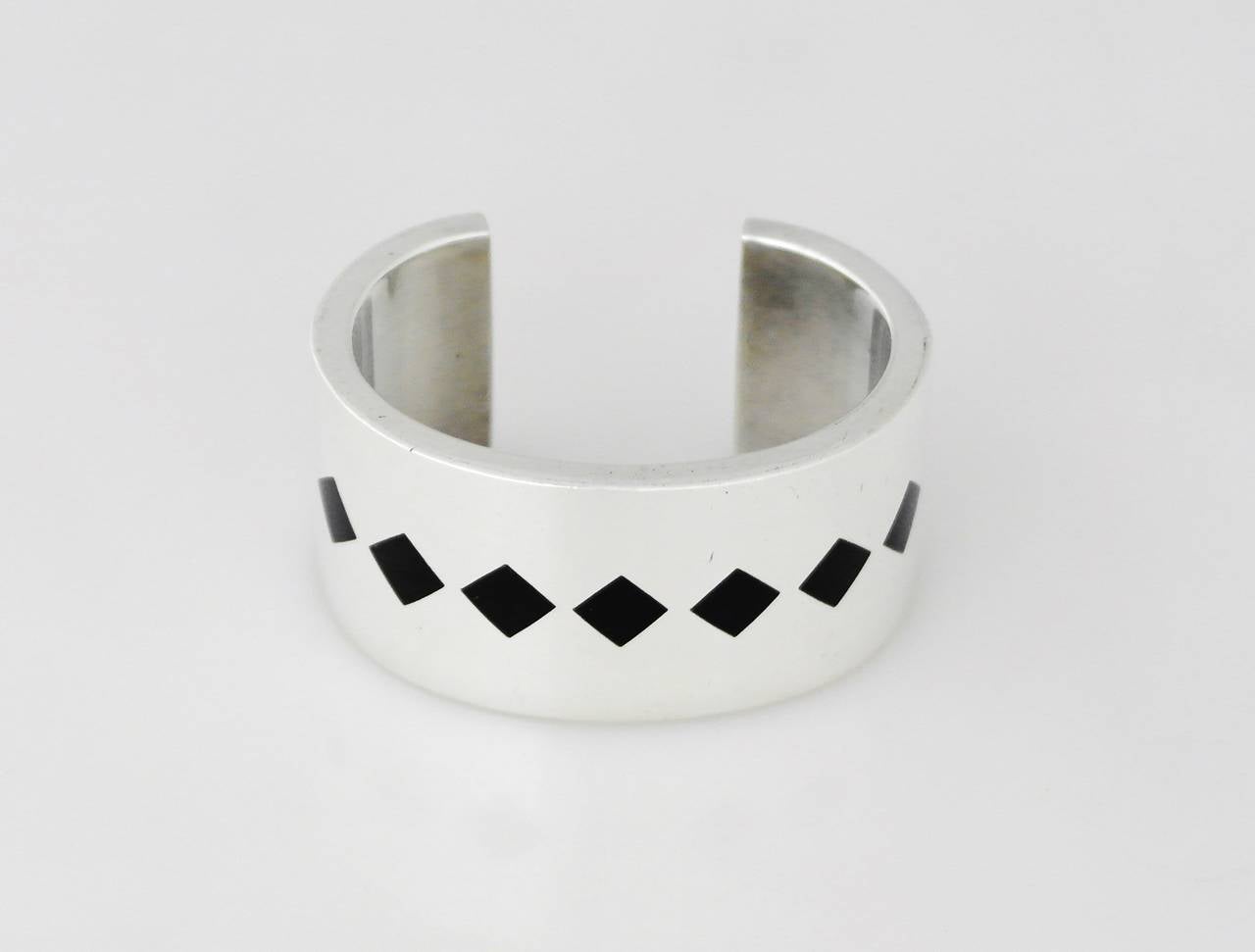 Being offered is a .970 Silver cuff bracelet by Antonio Pineda of Taxco, Mexico. Heavy gauge hand wrought piece in a modernist design with diamond shape onyx inlay. Dimensions: wearable 6 1/2