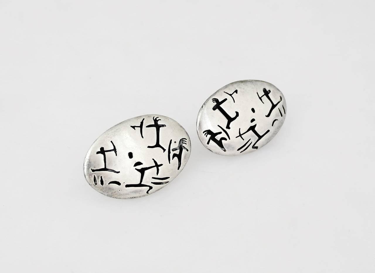 Being offered are a pair of .970 silver cufflinks by Antonio Pineda of Taxco, Mexico. Comprising a shadowbox design with pierced warrior motifs. Dimensions: 1 3/4
