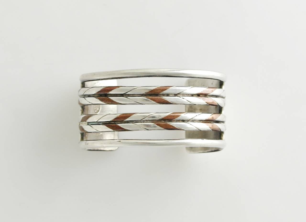 Being offered is a circa 1940 sterling silver cuff bracelet by William Spratling of Taxco, Mexico, comprising interwoven silver and copper bands designed of heavy gauge silver. Dimensions 1 3/8