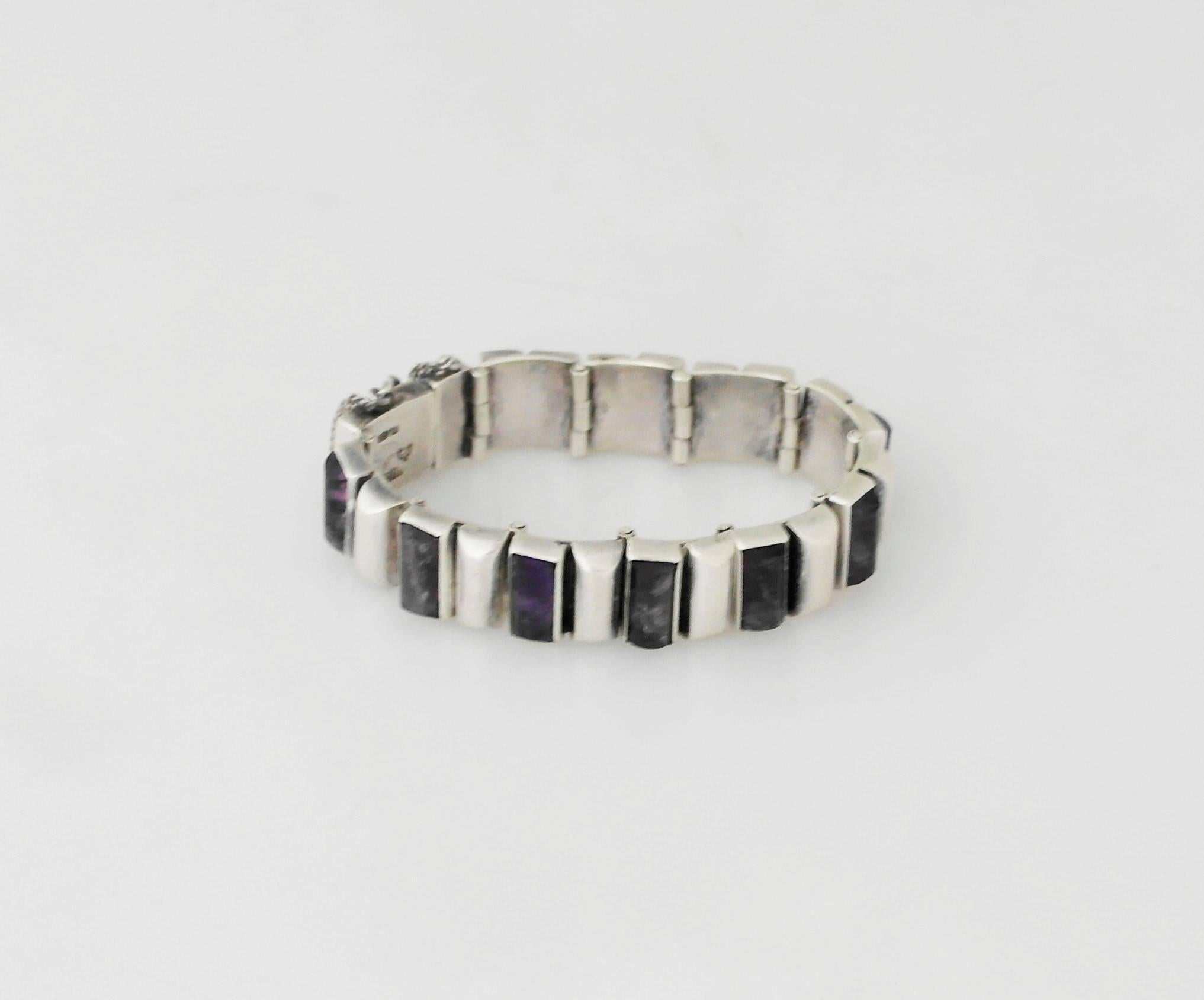Being offered is a .970 silver link bracelet by Antonio Pineda of Taxco, Mexico; comprising rectangular domed links with alternating bezel set amethyst stones; tongue & box closure; security chain. Dimensions: 1/2