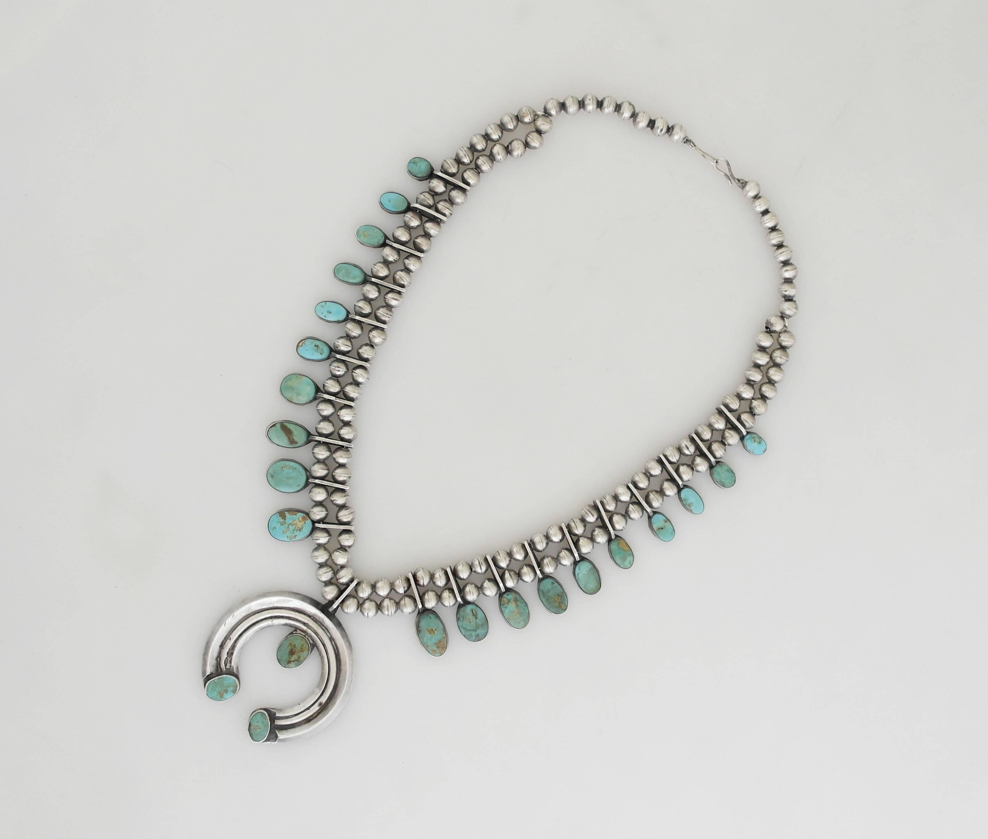 Being offered is a sterling silver necklace made by a skilled Native American silversmith. Beaded link necklace supporting bezel set turquoise stones; large pendant also decorated with turquoise. Dimensions: 23 inches (wearable); pendant is 3 inches