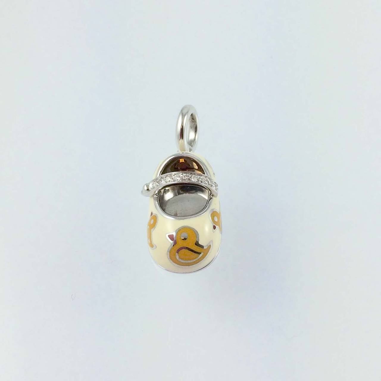 Aaron Basha 18K white gold, white enamel with yellow ducks baby shoe charm with diamond strap, pave set with 9 full cut round diamonds weighing .07 carats, G color, VS clarity, suspended from a 18K white gold bale.