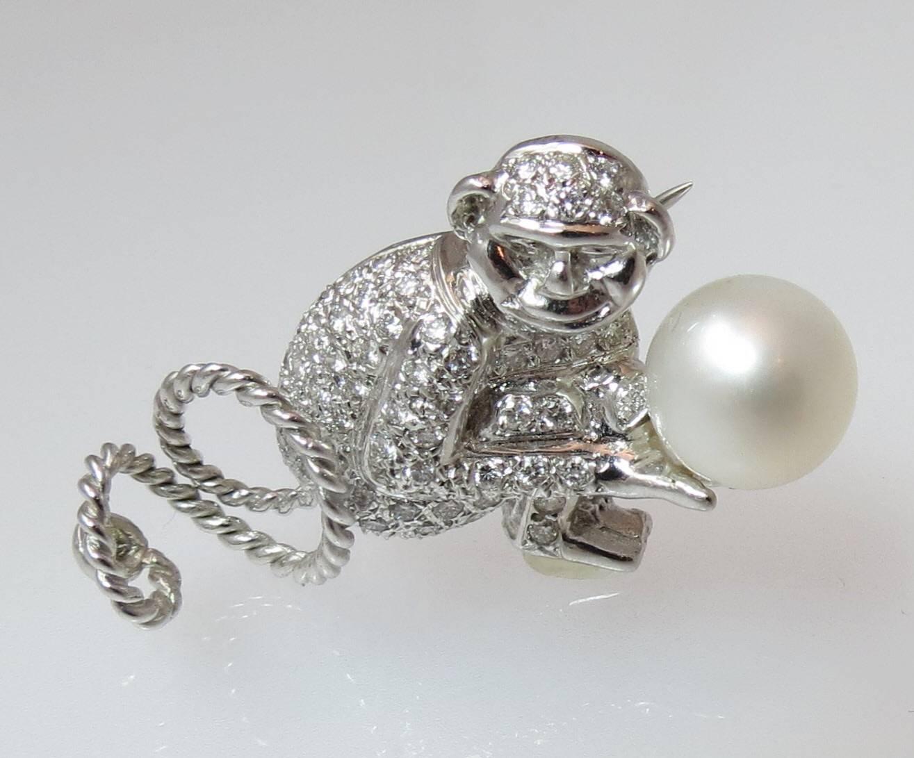 Adorable 18K white gold diamond and South Sea pearl monkey pin, set with 78 full cut round diamonds weighing approximately 1.17cts and one South Sea 9.8mm.