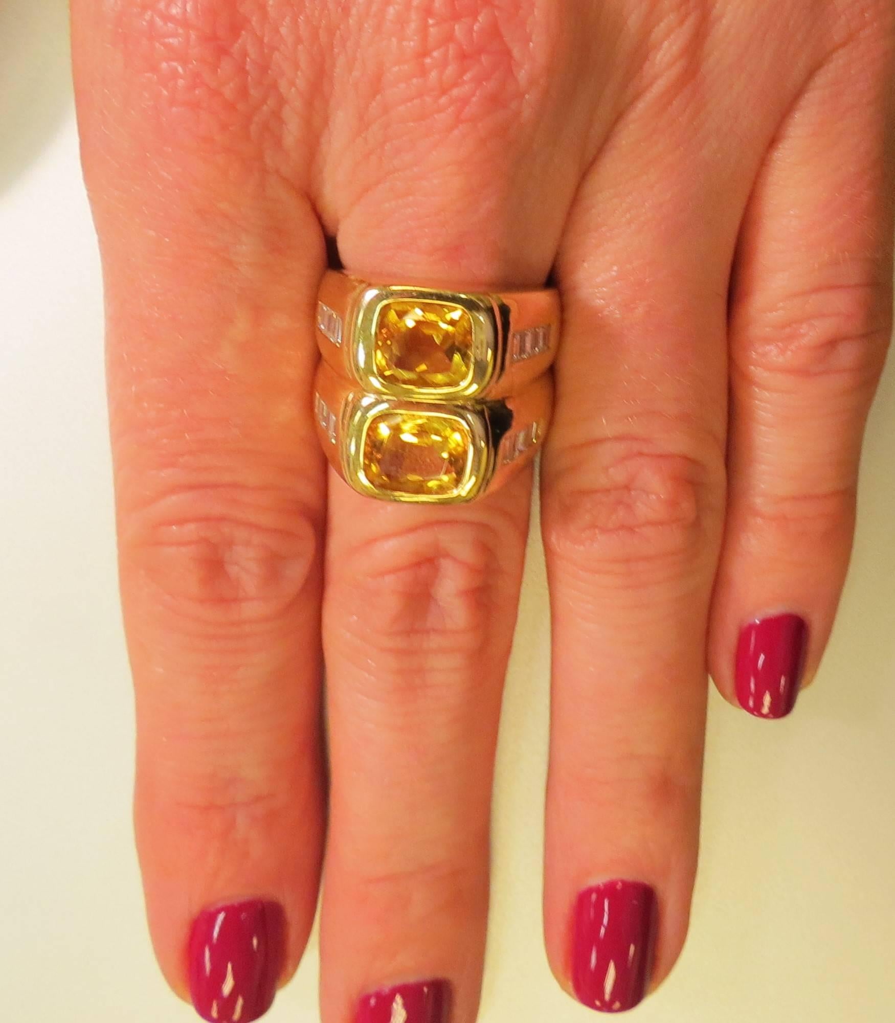 Contemporary 18K yellow gold wide band ring bezel set with 2 Emerald cut Citrines and 16 baguette diamonds weighing about .85cts total.

Finger size 6, may be sized.