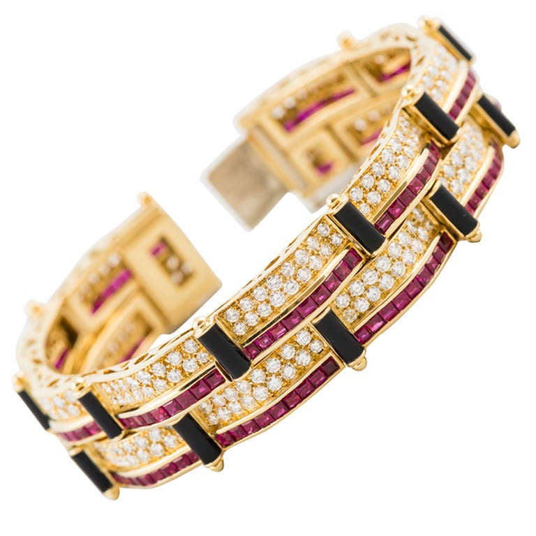 Picchiotti 18K yellow gold bracelet set with 159 faceted square rubies weighing    7.07 carats, 302 full cut round diamonds, pave set, G color, VS clarity, weighing 13.53 carats, with black onyx cylinders.