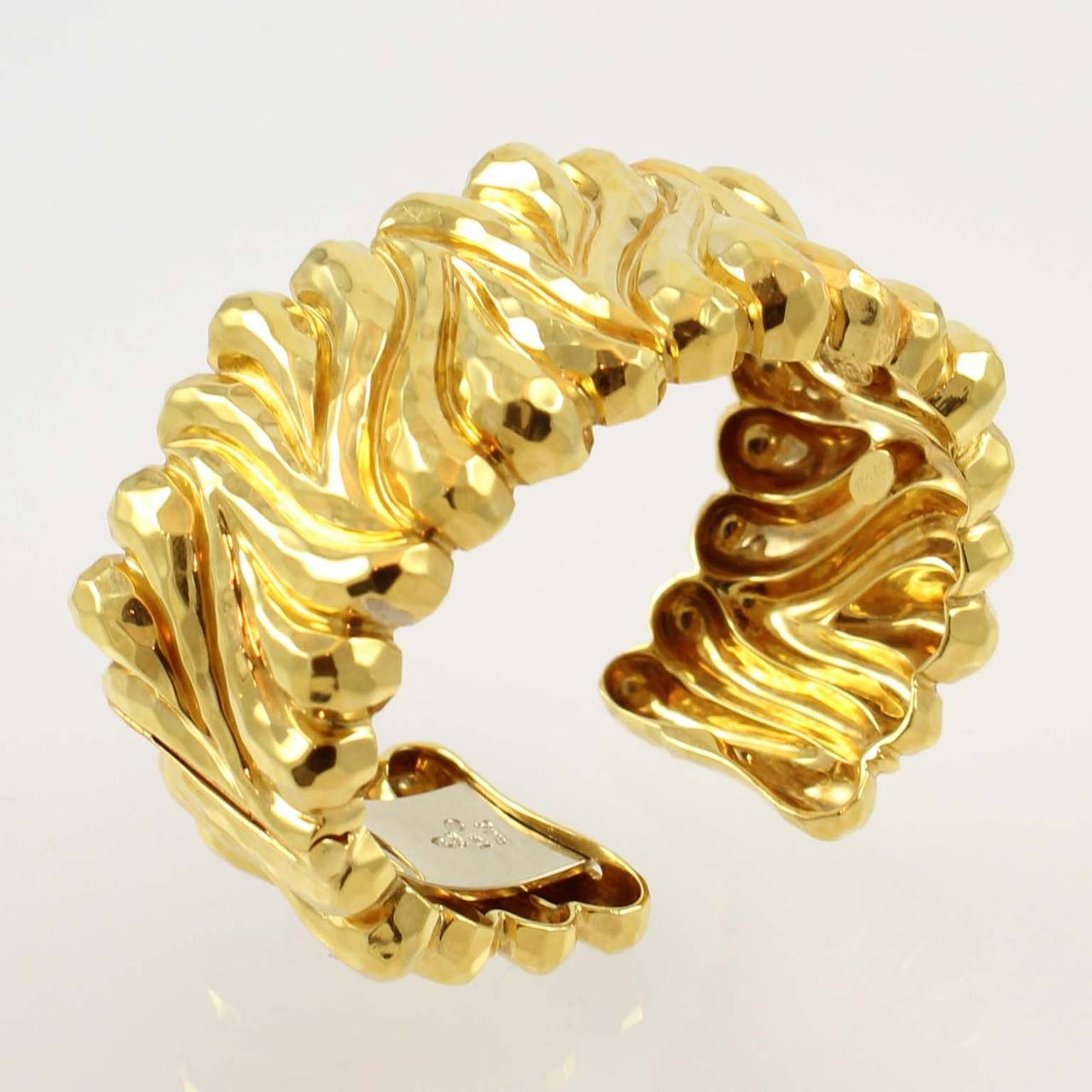 Henry Dunay 18K yellow gold faceted cuff bracelet, with a hinge, weighs 106.52 grams.