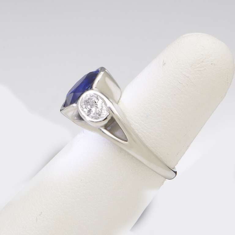 Faceted oval Ceylon blue sapphire, weighing 3.60 carats  set in partial
 platinum bezel, with two oval diamonds,  weighing .90 carats, G color, VS horizontally set in  platinum bezels on a custom designed platinum shank.