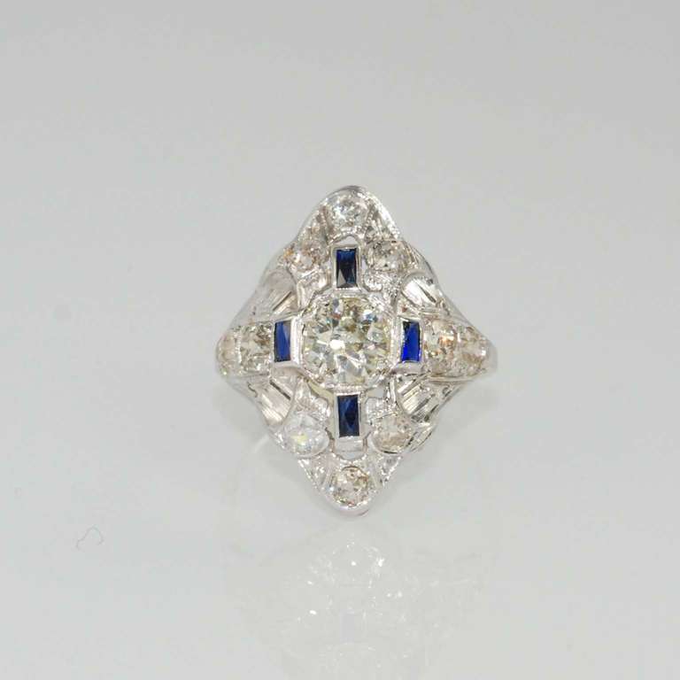 1920s filigree diamond and sapphire ring, prong set in octagon bezel with one  European cut round diamond weighing .68 carats, IJ color, SI clarity and 10 prong set European cut round diamonds weighing 1.25 carats total and 4 bezel set baguette blue