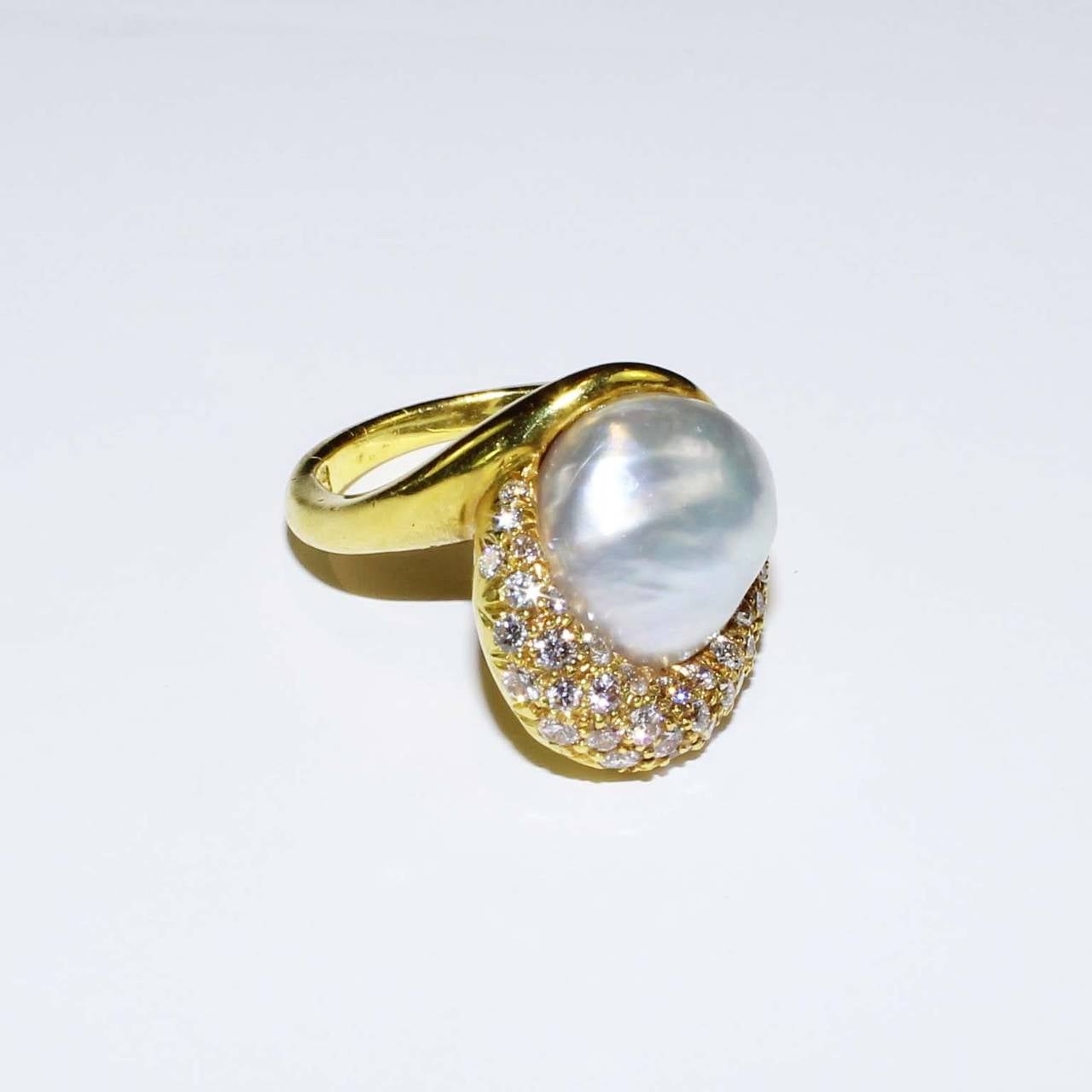 Henry Dunay, 18K yellow gold ring set with one natural pearl and pave set with 37 full cut round diamonds, weighing .75cts, Pearl measures 13mmx 12.5mm. Finger size 7.5, may be sized.