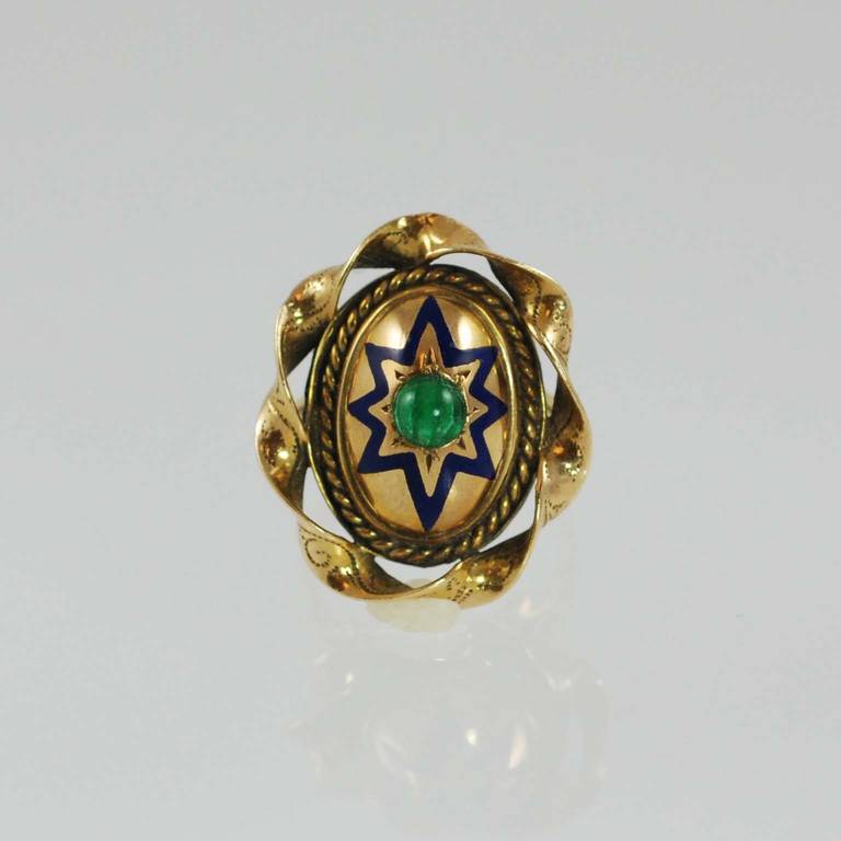 14K yellow gold ring prong set with one cabochon green emerald about     4.5mm, with blue enamel design.

Finger size 6.75. May be sized.