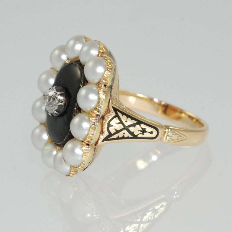 Victorian yellow gold and black enamel ring prong set with one European cut round diamond weighing .46 carat, I color, SI clarity and 12 cultured pearls. 

Finger size 7.5
May be sized