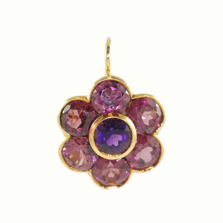18K yellow gold rhodolite garnet and amethyst flower earrings bezel set with 2 round amethysts and 12 round bezel set rhodolite garnets suspended from a wire lever back.