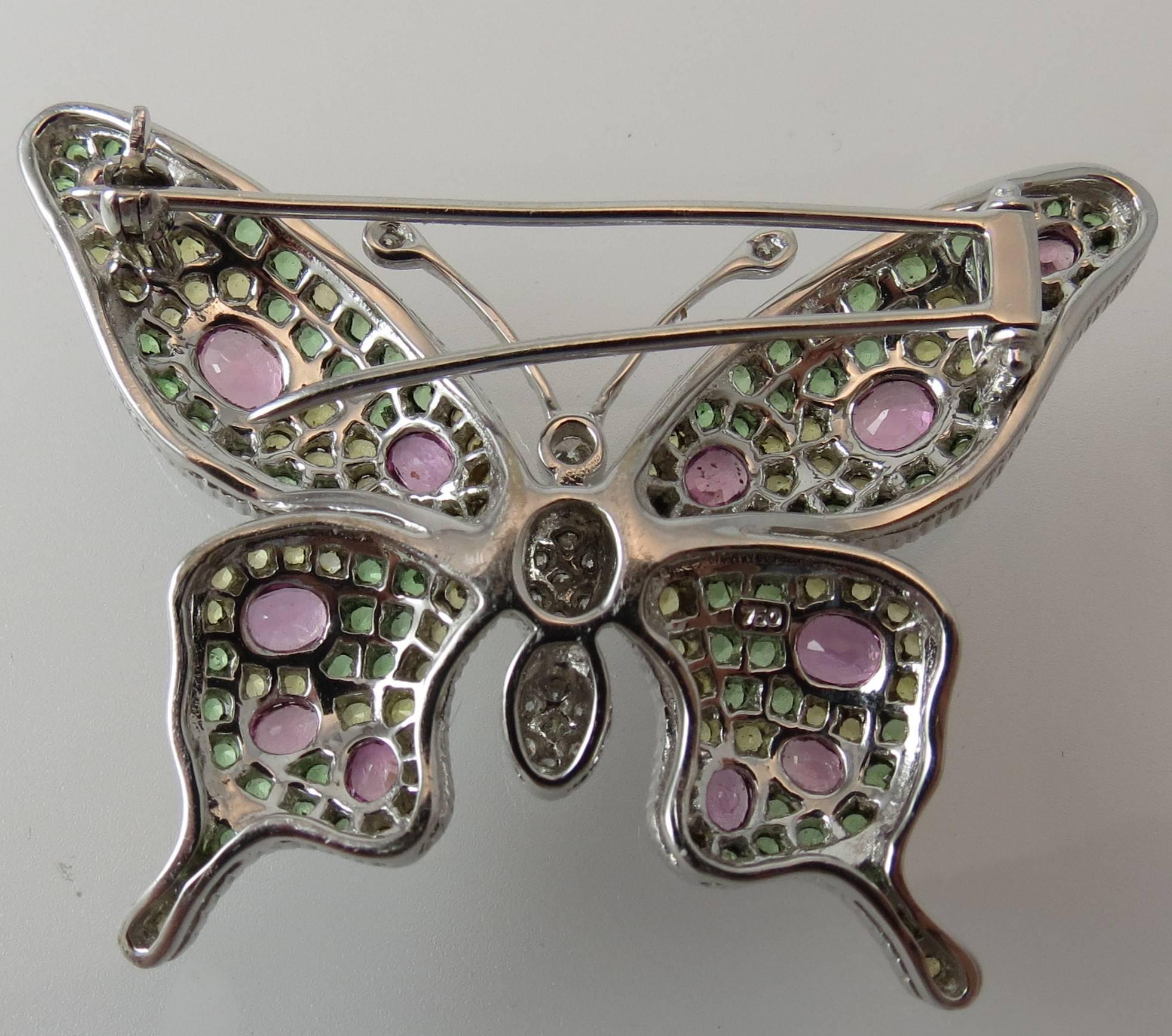 18K white gold Butterfly pin set with 17 round diamonds, pave set, weighing  .29cts,12 oval pink sapphires, prong set, weighing 2.71cts, 75 yellow sapphires, prong set, weighing 1.87cts and 70 tsavorites, prong set, weighing 2.23cts.