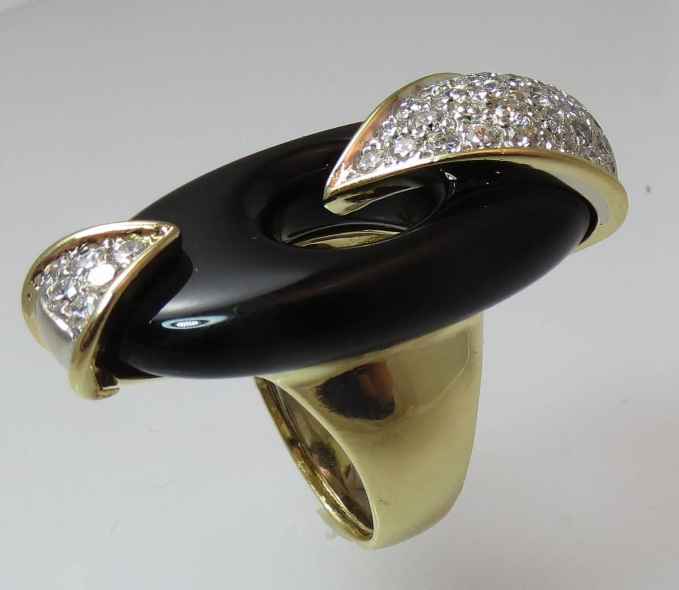 Dramatic 18K yellow gold and black onyx ring set with 41 full cut round diamonds weighing about 1.76cts