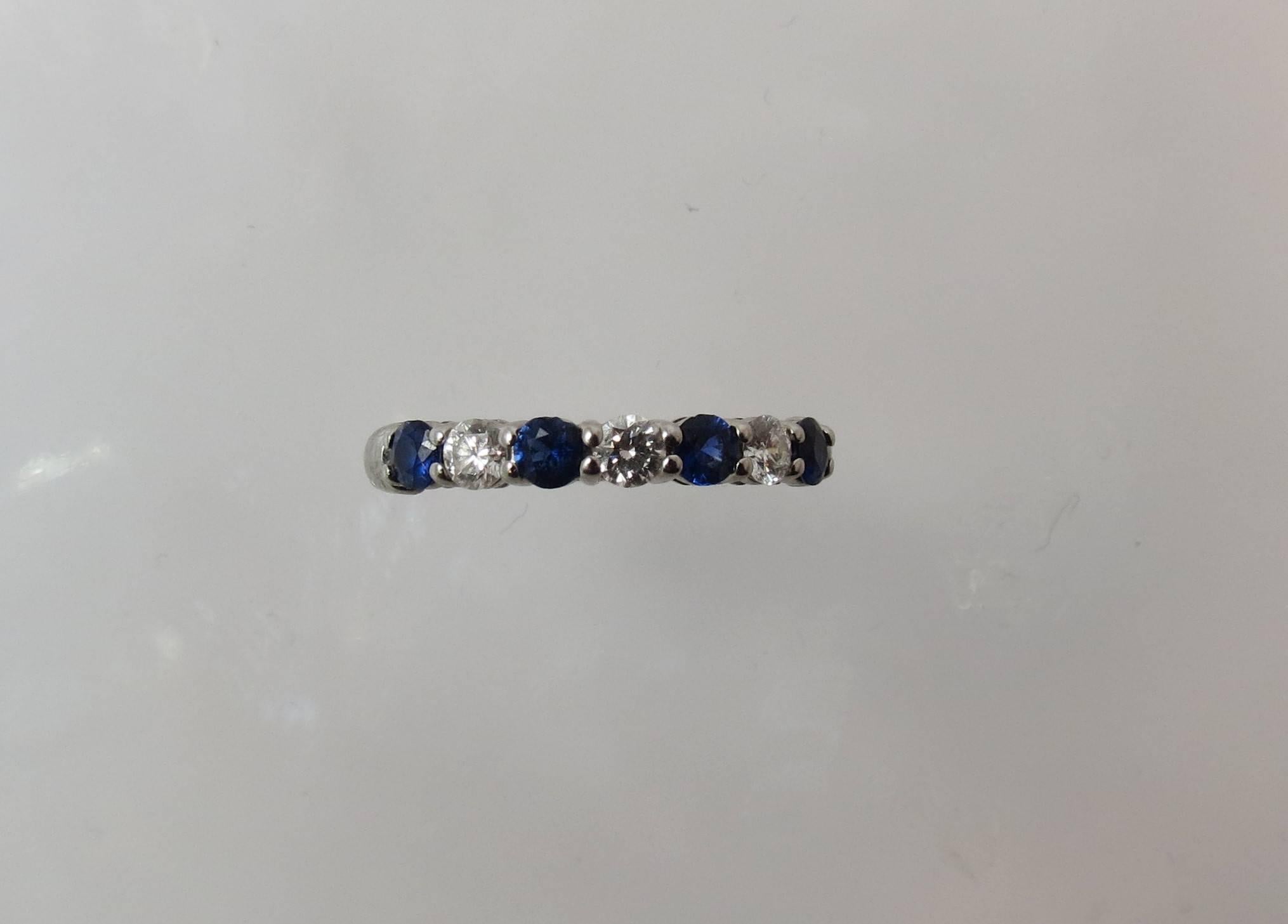 Tiffany shared-setting band ring with a half circle of round blue sapphires weighing .40cts total and round brilliant diamonds weighing .24cts total,  in platinum, 3mm wide setting

Current Tiffany retail is $4675