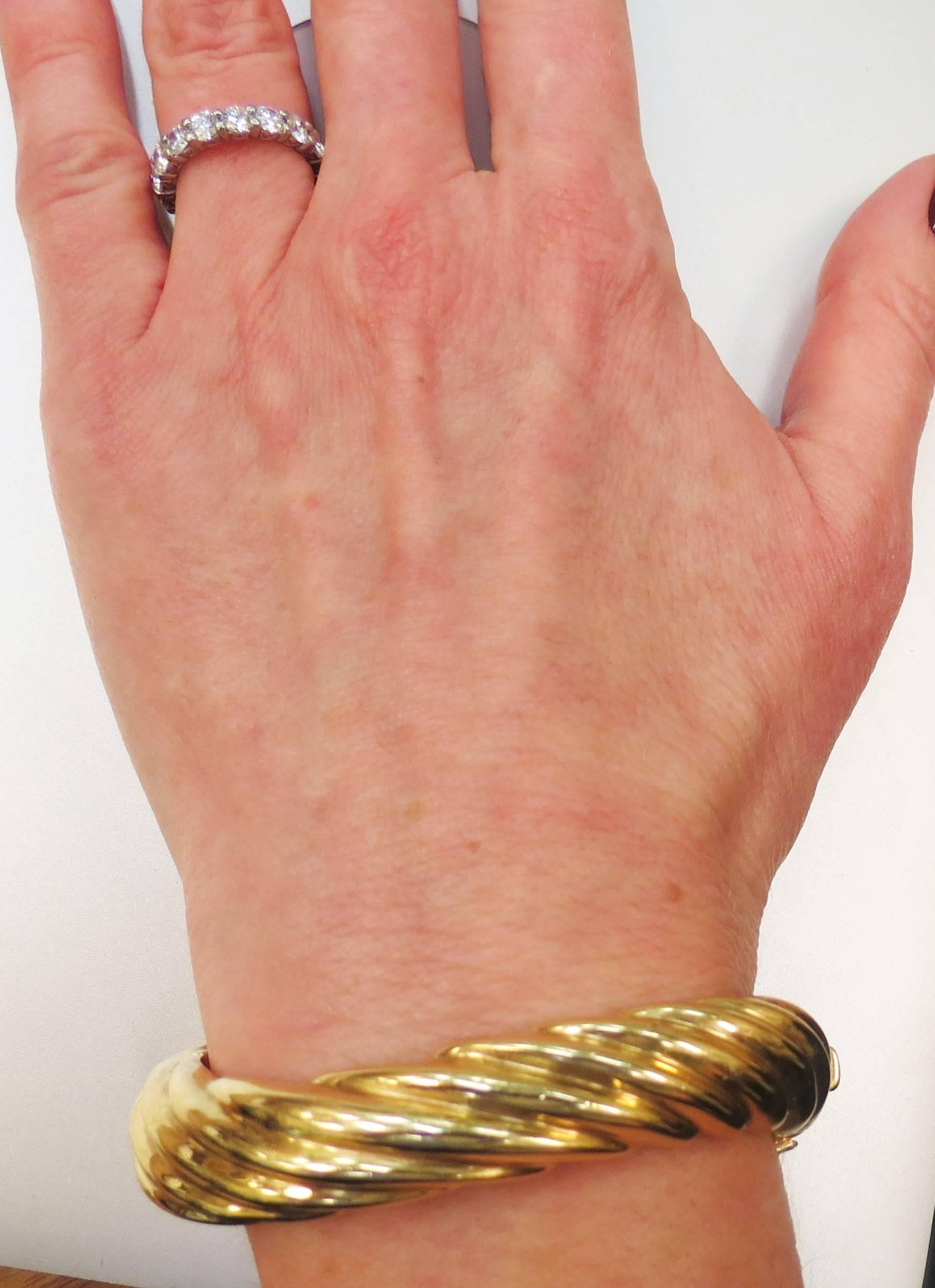 14K yellow gold twist style bangle bracelet 
Width .5 inches