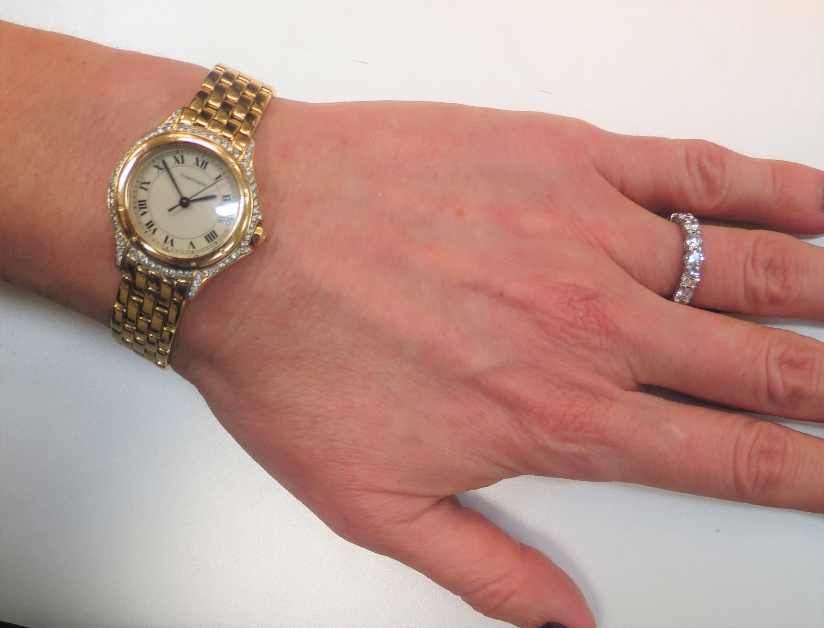 Ladies Pre-owned Cartier 18K yellow gold diamond Cougar bracelet watch, quartz movement, Roman Numerials, Sweep Second hand, Date window, Diamond Bezel with 72 full cut round diamonds, case size 26mm.
