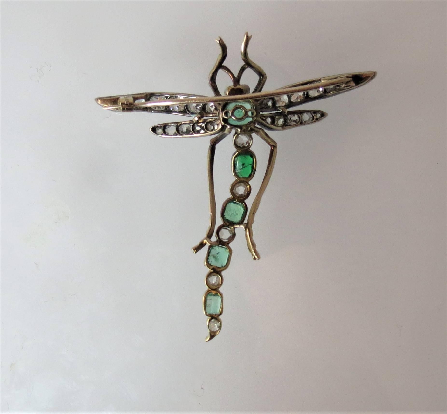 Fabulous vintage 14k yellow gold and silver dragon fly pin set with five faceted green emeralds weighing about 2.20cts and 33 rose cut and old mine cut diamonds weighing about 2.80cts, with two cabochon garnet eyes.