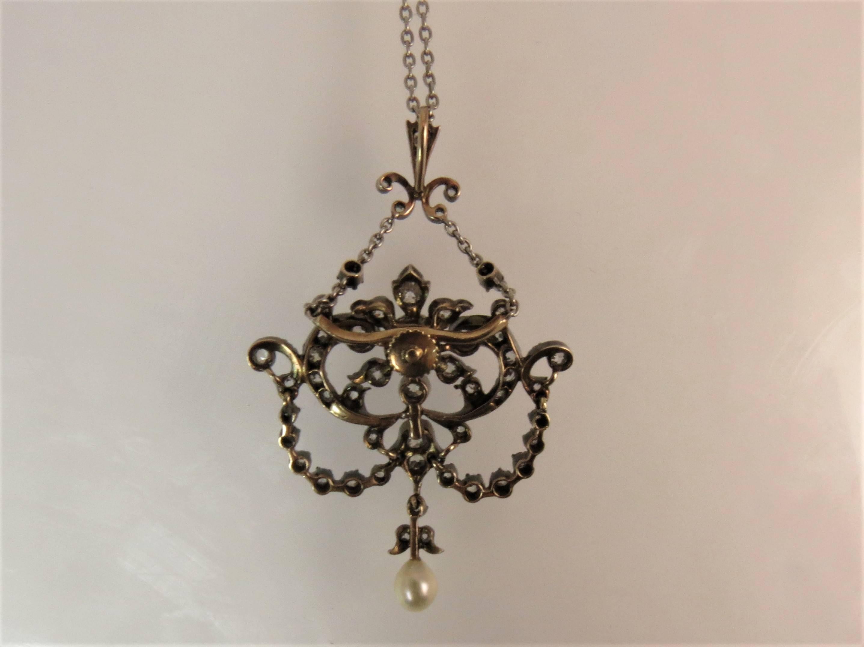 Beautiful Edwardian Pendant, set with 51 old European cut diamonds weighing approximately 1.25cts, H-I color, VS clarity and two natural pearls, center pearl  5mm and tear drop pearl 5.4mm x 4.3mm, measuring 1.13 x 1.75 inches total suspended from