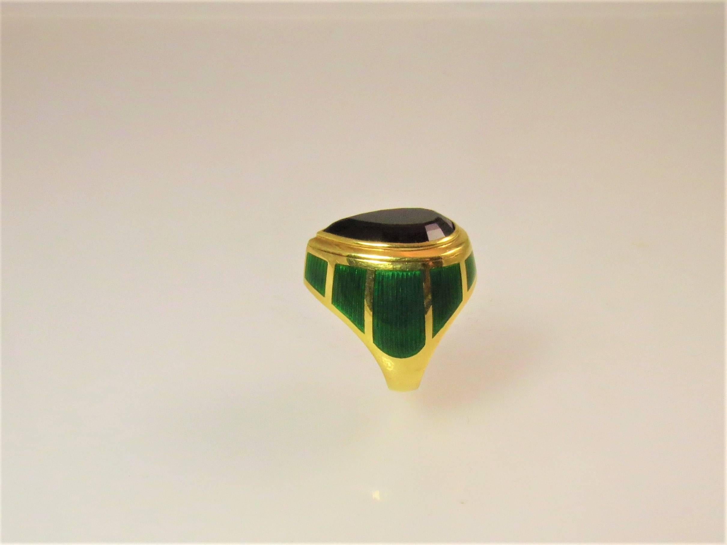 De Vroomen 18K yellow gold and green enamel ring, set with one pear shape   faceted amethyst weighing 10.54cts.
Finger size 7. May be sized.