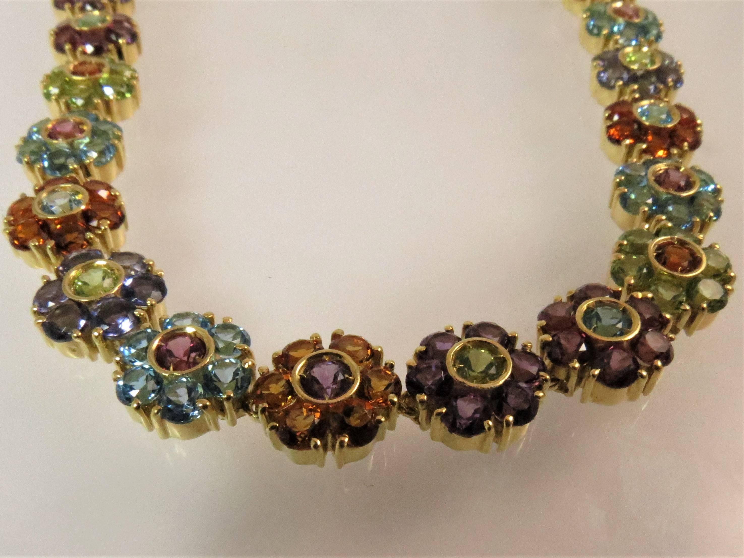 18K yellow gold multi-colored flower design necklace set with 266 round faceted amethyst, blue topaz, citrine, iolite, peridot, and pink tourmaline. 
Length is 16.5 inches
Diameter of flowers are .38 inches