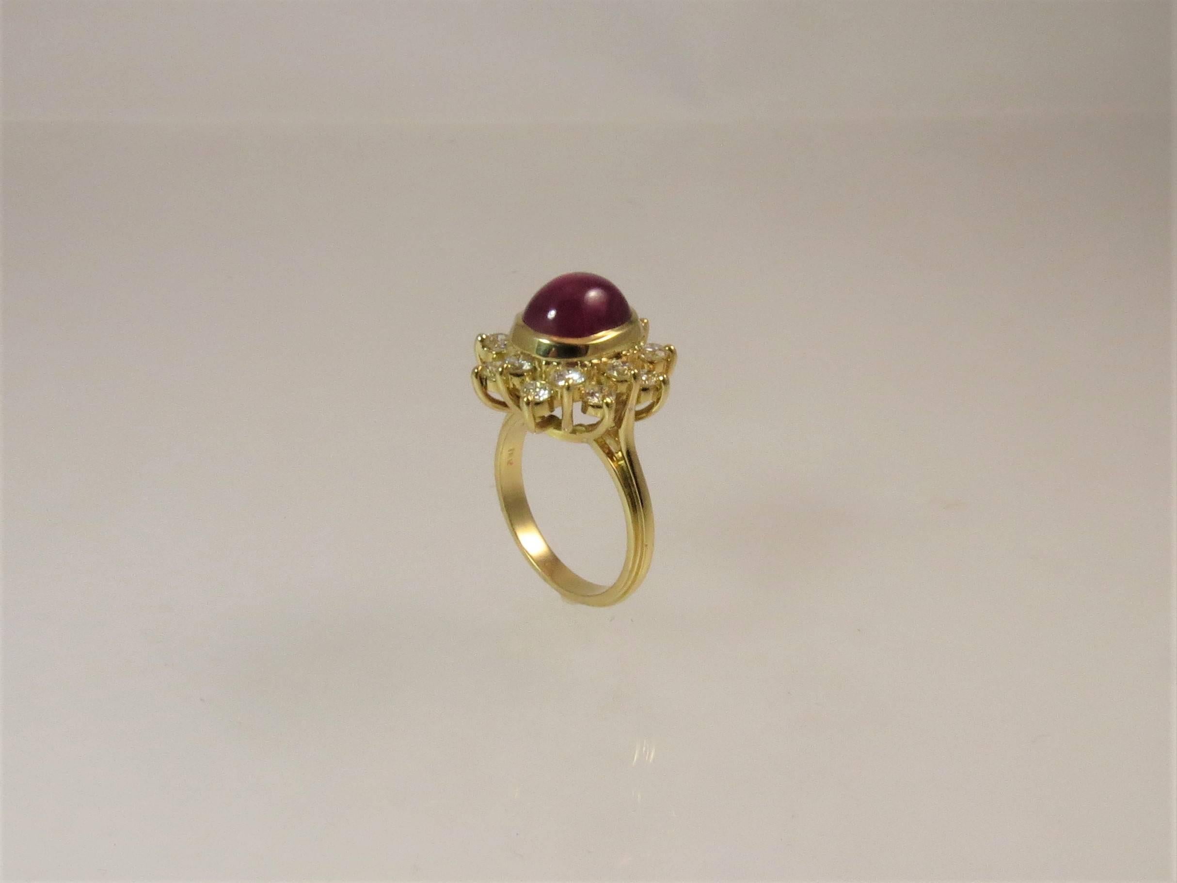 18K yellow gold ring, prong set in center with one Star Ruby weighing 7.62cts surrounded by 16 full cut round diamonds weighing 1.31cts, G-H color, VS-SI clarity.
Finger size 6.75. May be sized.