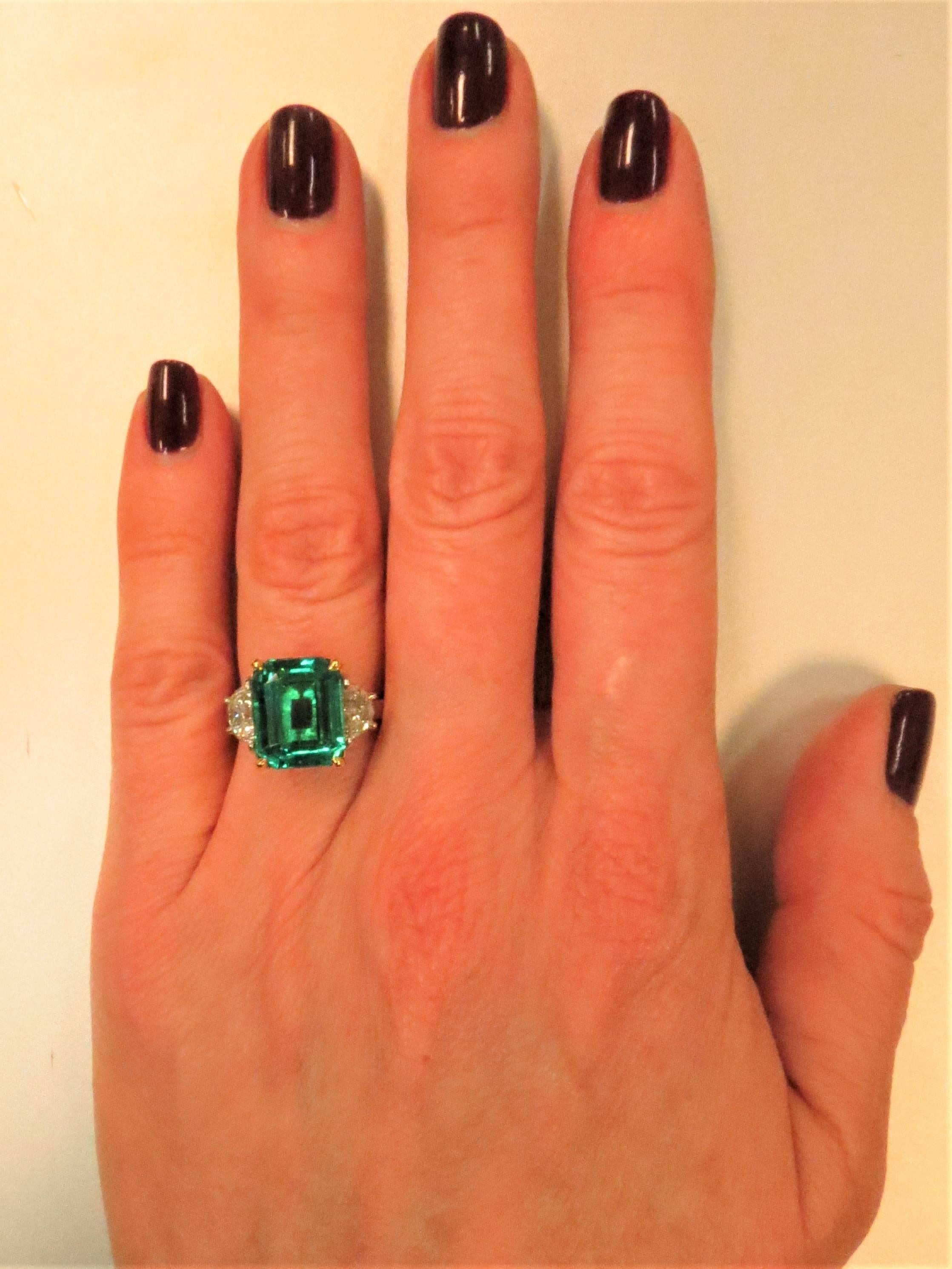 Beautiful platinum ring, prong set in 18K yellow gold, with emerald cut emerald weighing 6.14cts and two half moon diamonds weighing 1ct total, G color, VS clarity
Size 6, may be sized