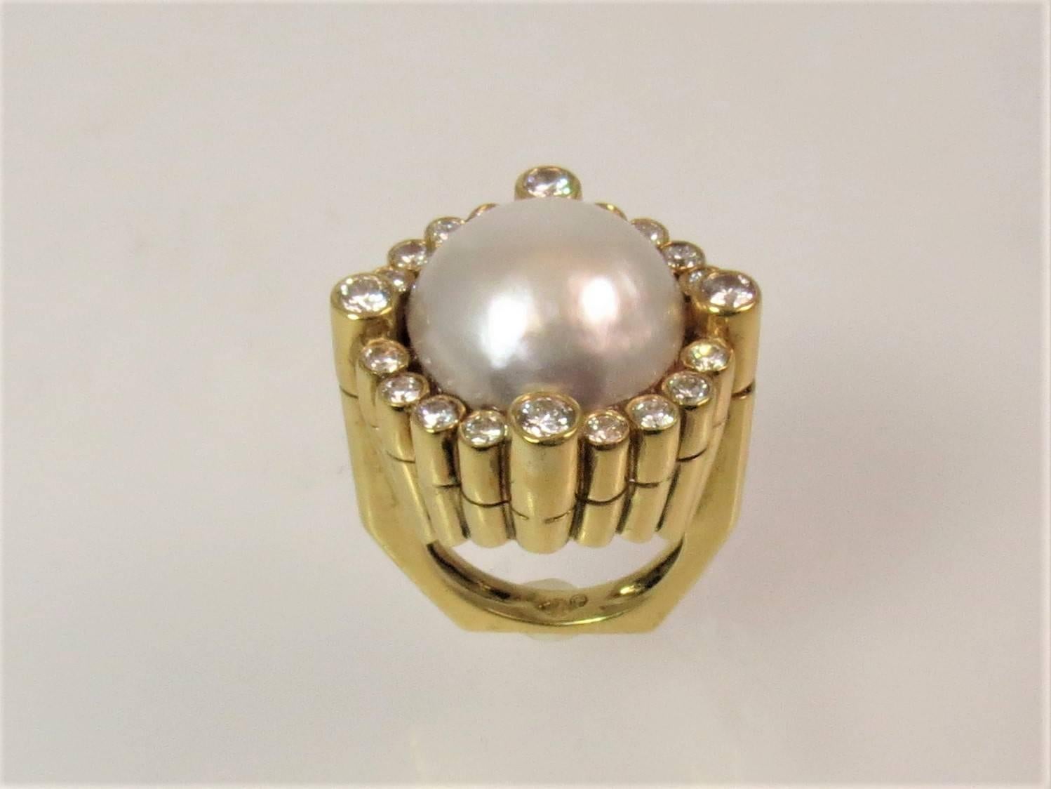 bague en or jaune 18K, avec perle Mabe mesurant 15.5mm et 20 diamants ronds pleine taille pesant 1.29cts, couleur G-H, pureté VS
Taille du doigt 5,25. Peut être dimensionné