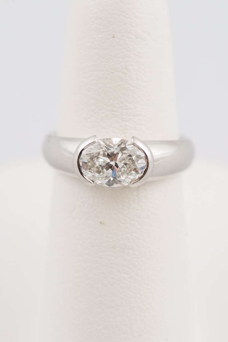 Oval diamond, weighing 1.50 carat, F color, VVSI clarity, GIA certified, horizontally set in a partial bezel 