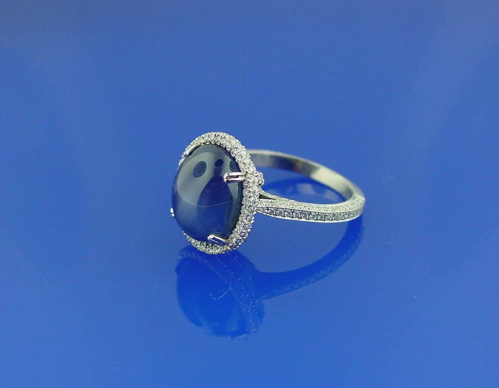 A  Cabochon Cut Star Sapphire Ring in a Platinum and Diamond Mounting. With a glamorous Art Deco feel, this contemporary ring features an 11.55 carat cabochon sapphire with AGTA Report #94014811 stating Burma (Myanmar), no heat . In a beautifully
