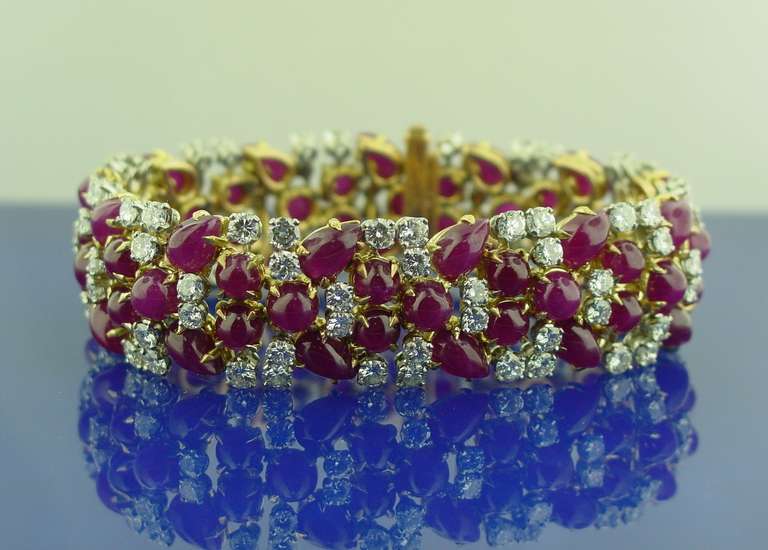 A diamond and ruby bracelet mounted in 18 karat yellow gold and platinum. The bracelet is set with approximately 15.60 carats of round cut diamonds and 84 carats of round and pear shaped rubies.