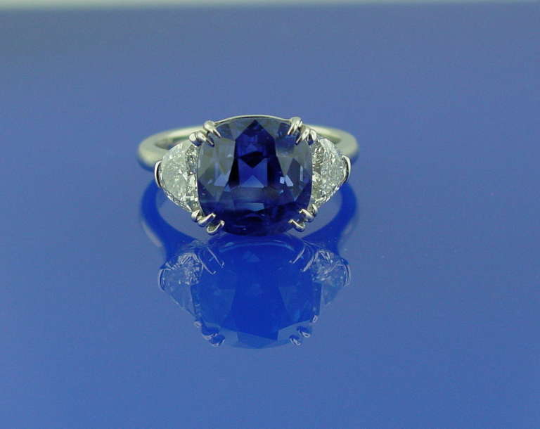 A sapphire and diamond ring mounted in platinum.The ring features a cushion shaped sapphire weighing 8.82 carats, flanked by two half moon diamonds weighing 0.98 carats.

With GIA certificate # 1146622590 stating the sapphire is Burma (Myanmar),