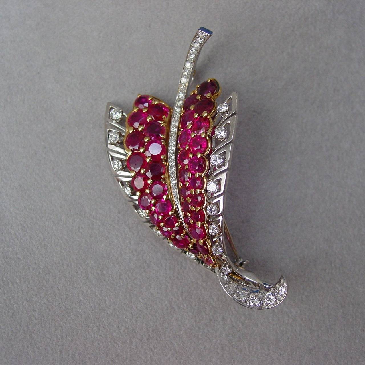 A Ruby and Diamond Foliate Brooch. This very pretty and well made brooch is mounted in 18 karat yellow gold and platinum with findings in 14 karat white gold. Numbered 10003. The body of the brooch is set with round cut rubies and full cut diamonds