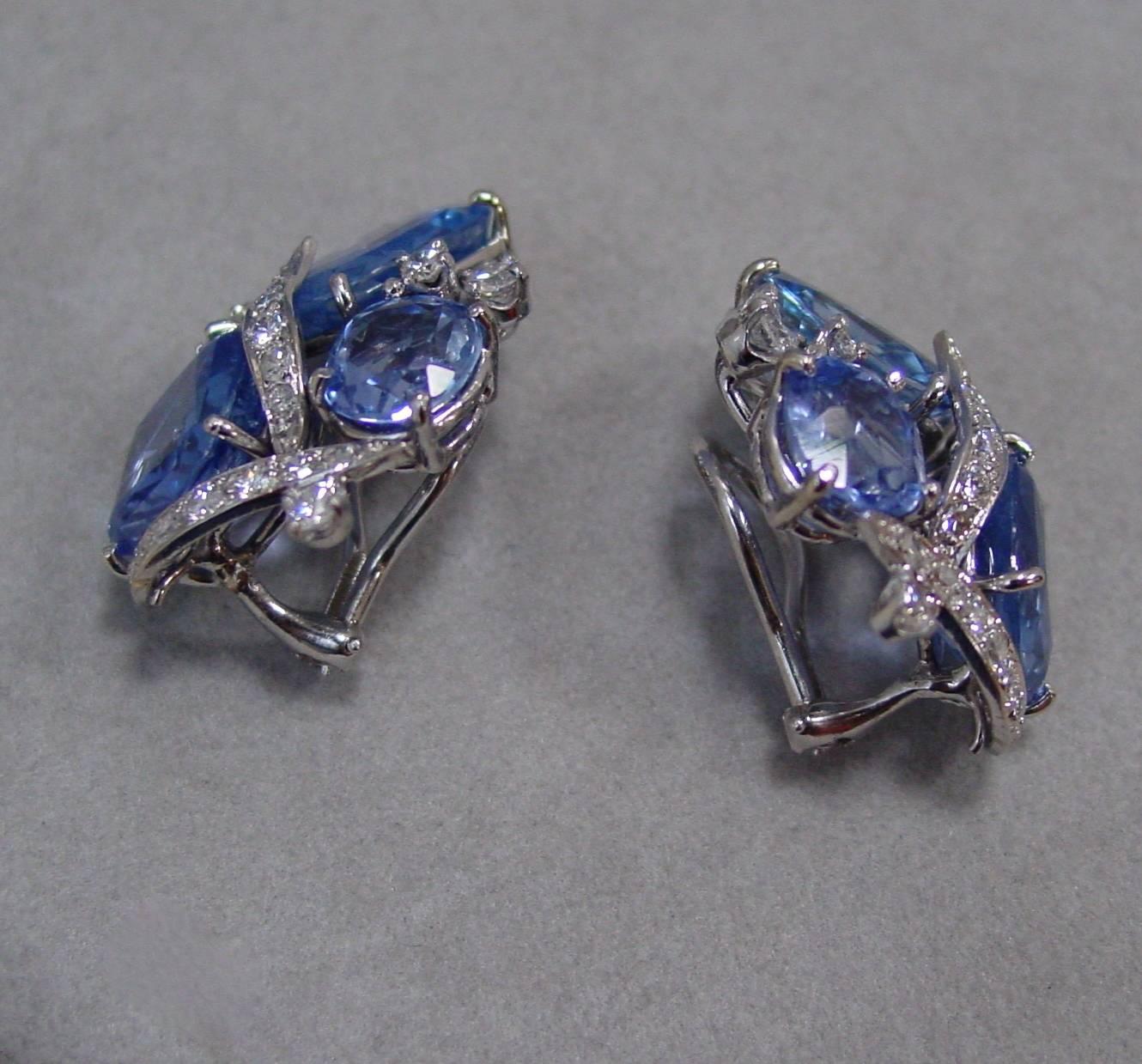A Pair of Cushion Shaped Sapphire and Diamond Cluster Earrings Mounted in 18 Karat White Gold. Set with 33.58 carats of gorgeous antique cushion shaped sapphires beautifully highlighted by 18 karat white gold and diamonds, these ear clips are simply