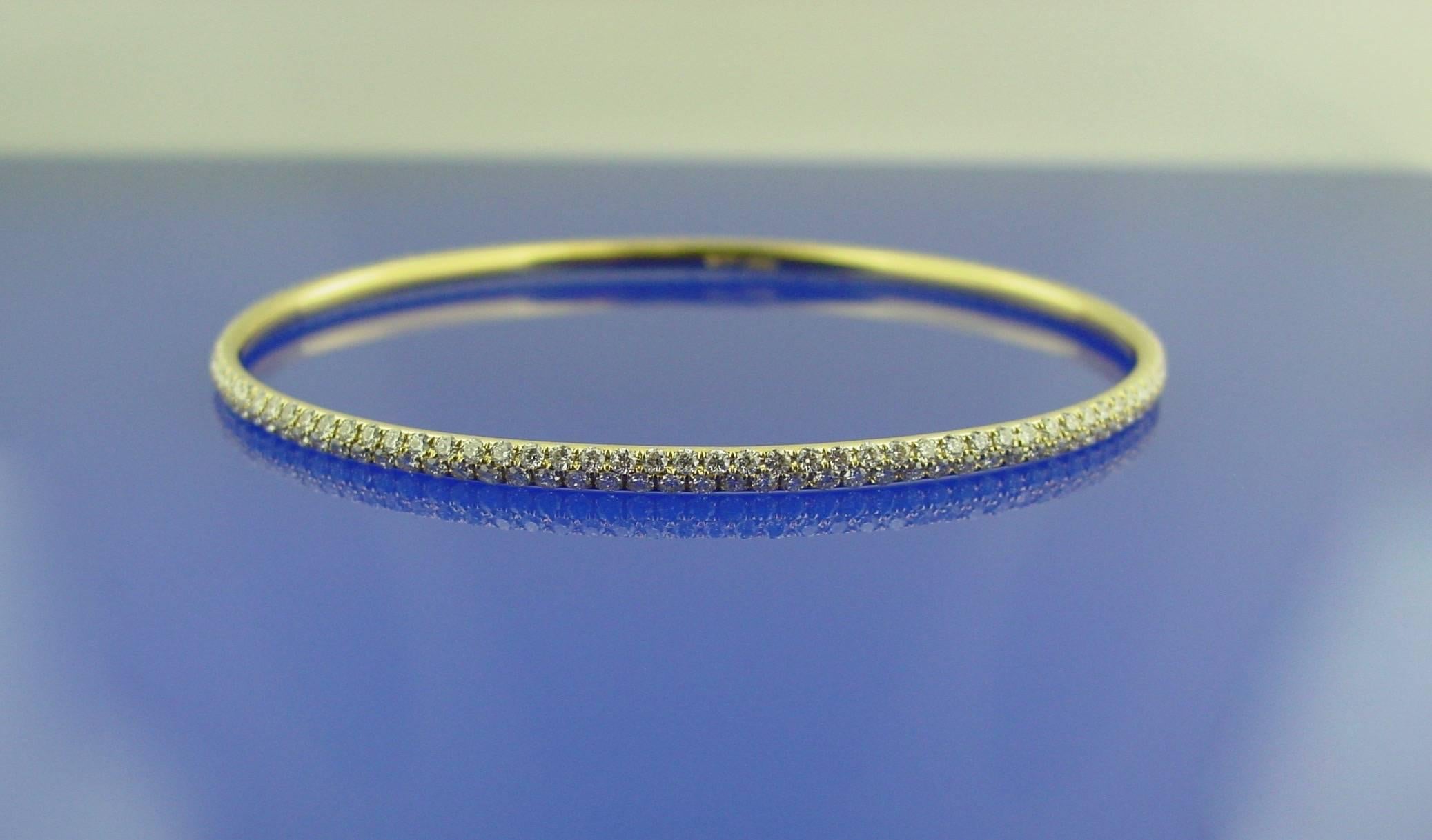 This elegant and eminently wearable bangle is encircled all around by two rows of round diamonds weighing 3.40 carats mounted in 18 karat yellow gold. Inner circumference of 7.13 inches.