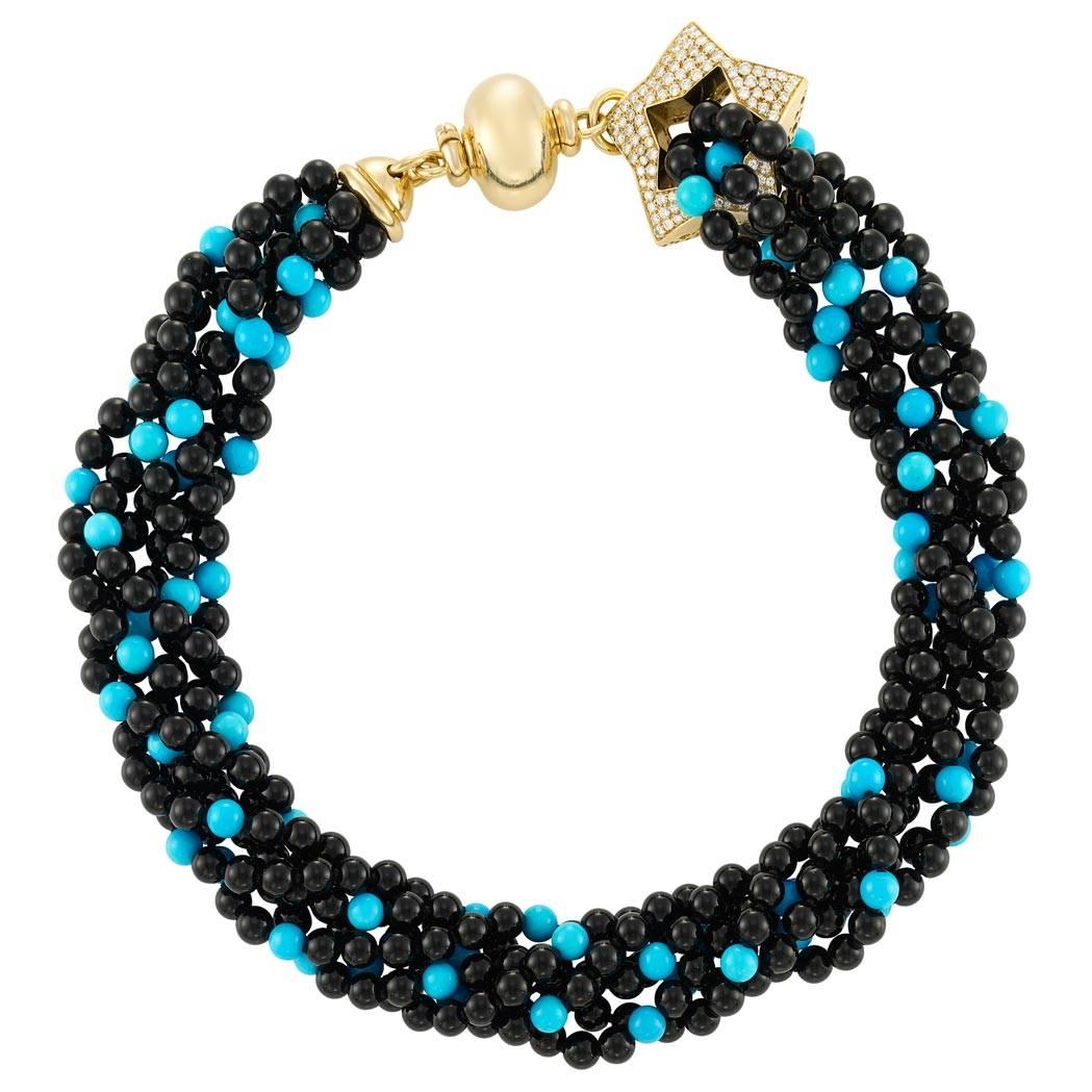 This bright and lovely six strand turquoise and onyx bead necklace is completed by a very stylish 18 karat gold and diamond star clasp. Measuring 18 inches and set with approximately 2.50 carats of round brilliant diamonds this is a wonderful and