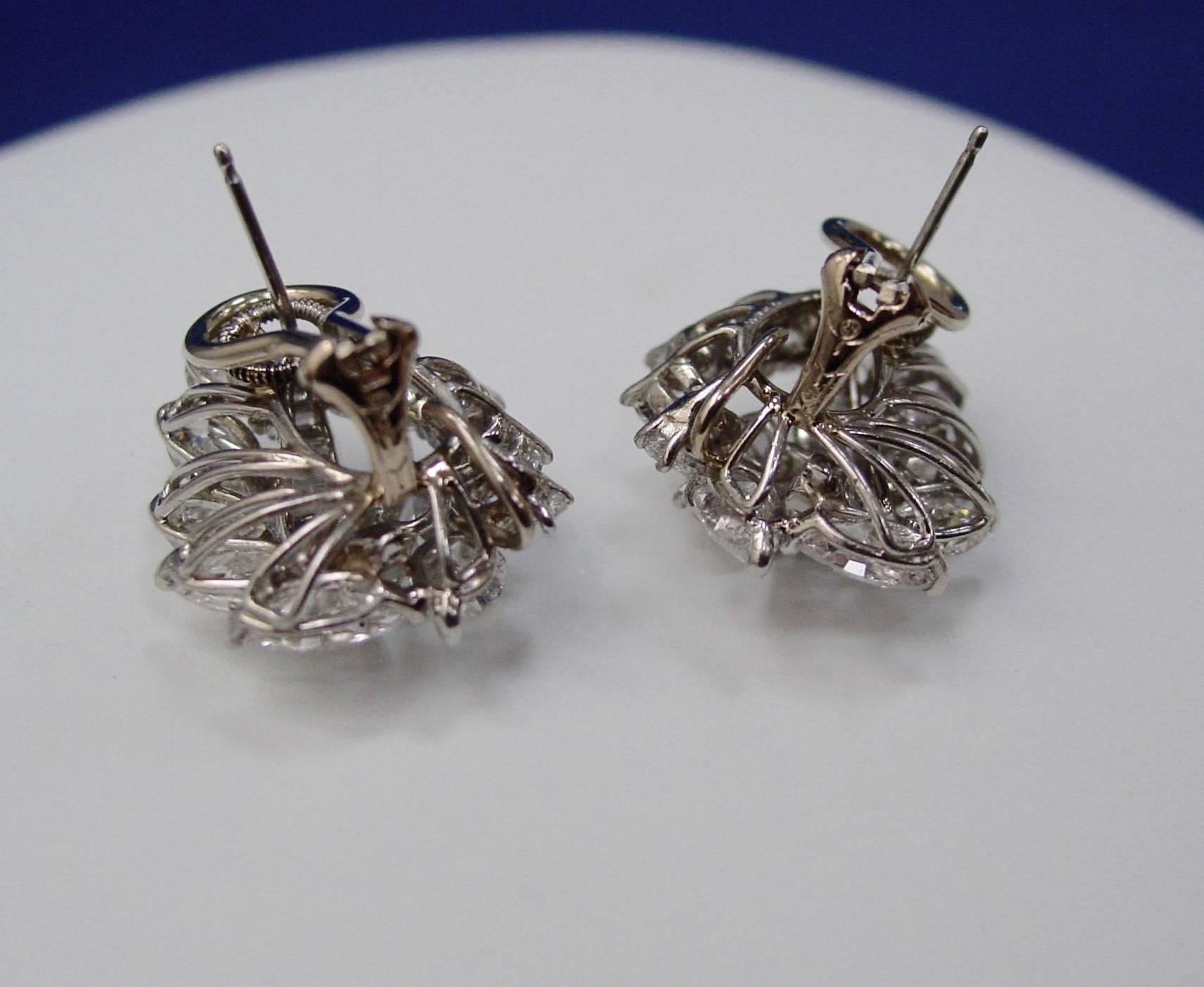  A classic pair of diamond and platinum cluster earrings by Oscar Heyman. Featuring pear, baguette and round shaped diamonds weighing approximately 9 carats in total and mounted in platinum with omega-style clip backs with maker's mark for Oscar