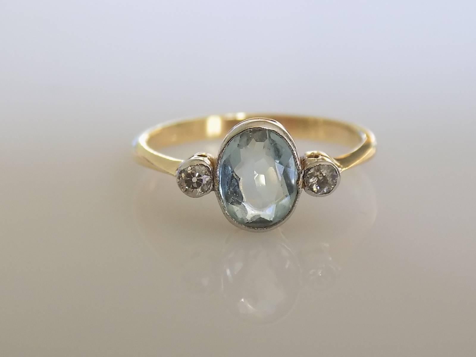 A Gorgeous Edwardian era old cut Diamond and Aquamarine trilogy ring. The stones in Platinum topped 18 Carat Gold bezel setting. Perfect as everyday ring. English origin. 
Size L 1/2 UK, 6.25 US can be sized. 
Aquamarine 8mm x 6mm. 
Marked for 18