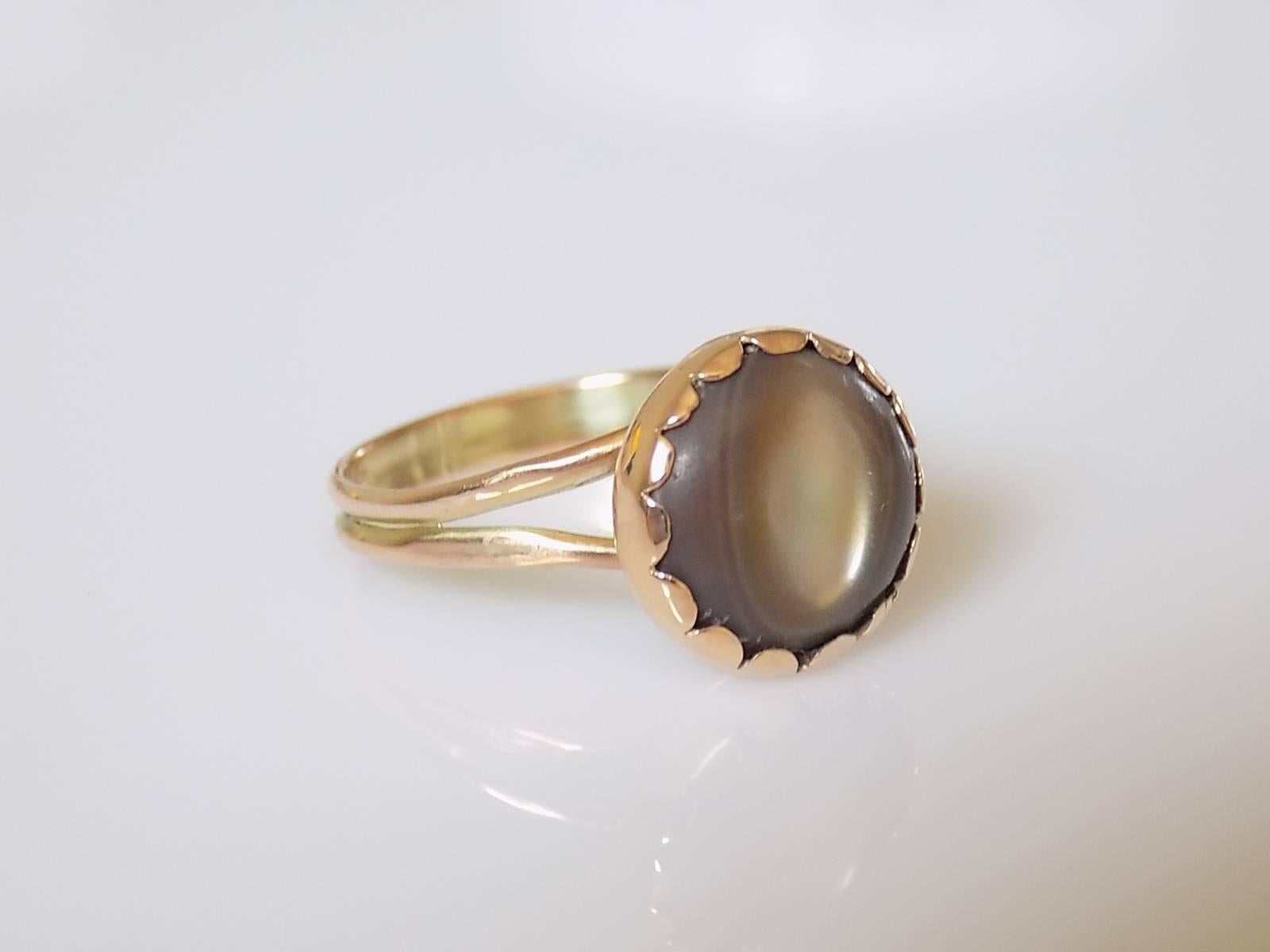 A Beautiful Victorian 9 Carat Gold and Mother of Pearl Cats eye ring. Mother of pearl with a rainbow of colors in the middle and in beautiful closed back setting. Rare find.

Size O 1/2 UK, 7.75 US.

Height of the face 13mm.

Weight