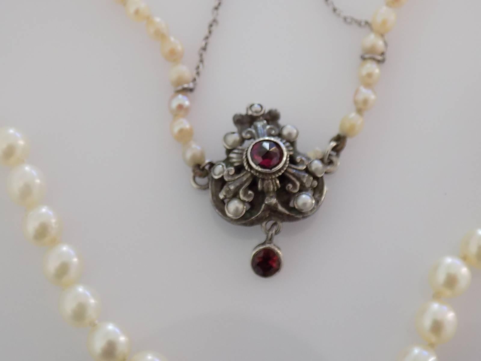 
An Antique early 1900s Pearl chocker necklace on a beautiful Sterling Silver, Garnet and split Seed Pearl clasp.
Total length including clasp 15 Inch. 
Pearls approx. from 3mm and 6mm.
Weight 15.1gr.
Marked 925 for Sterling Silver.