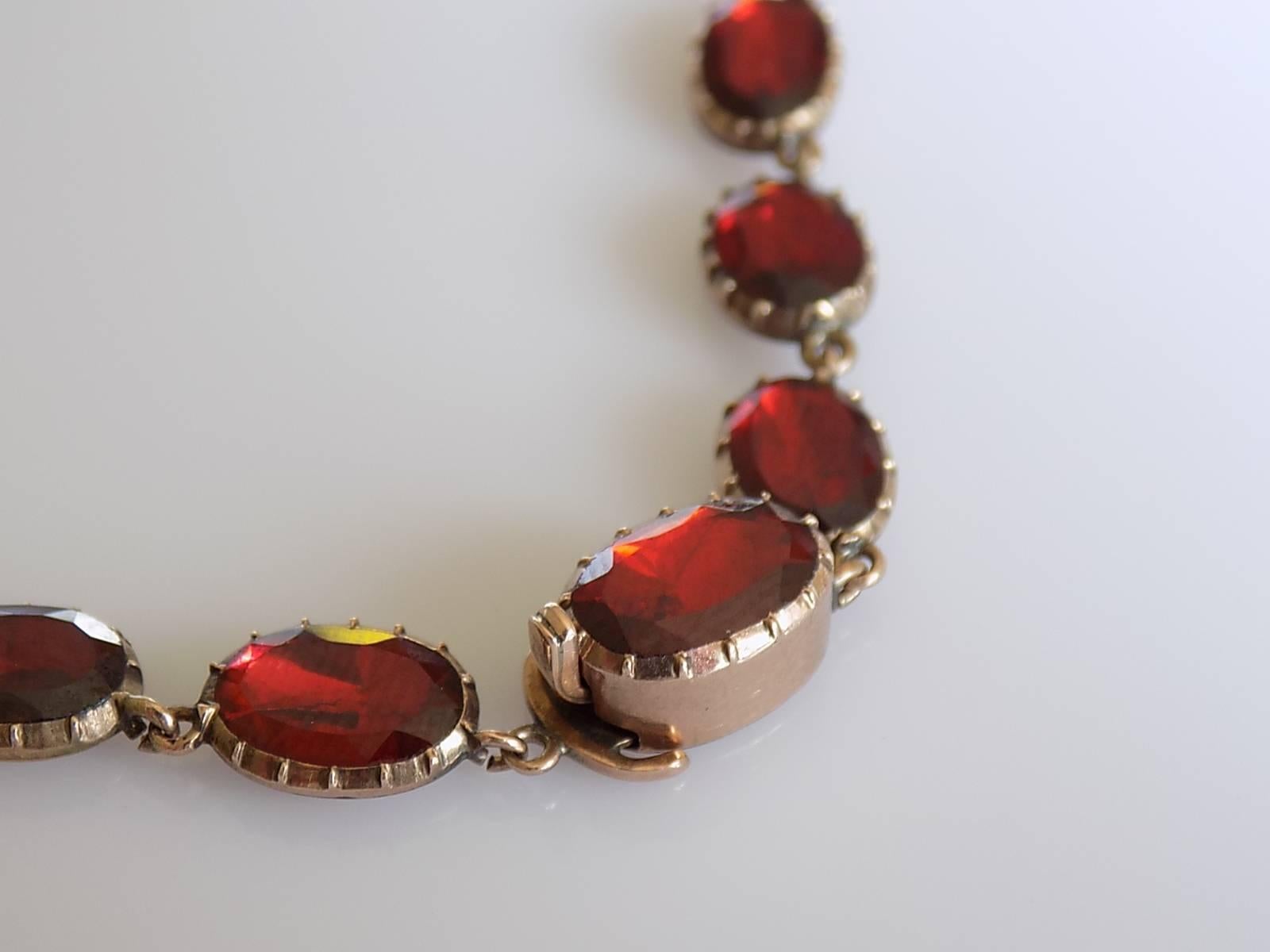 A Stunning Georgian c.1800 foil backed flat table cut Almandine Garnet Riviere necklace in 9 Carat Gold mount. The necklace complete with an original hinged catch ring for a pendant and push in clasp. English origin.
Total length including clasp 15