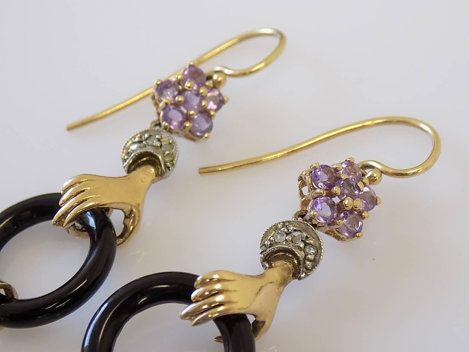 A Breathtaking Italian 14 Carat Gold drop earrings. Each earring designed as a hand with a rose cut Diamond cuff holding 16mm black Onyx and 7mm Cultured Pearl and Tanzanite flower above. Earrings made in Victorian style. Italian origin.
Total Drop