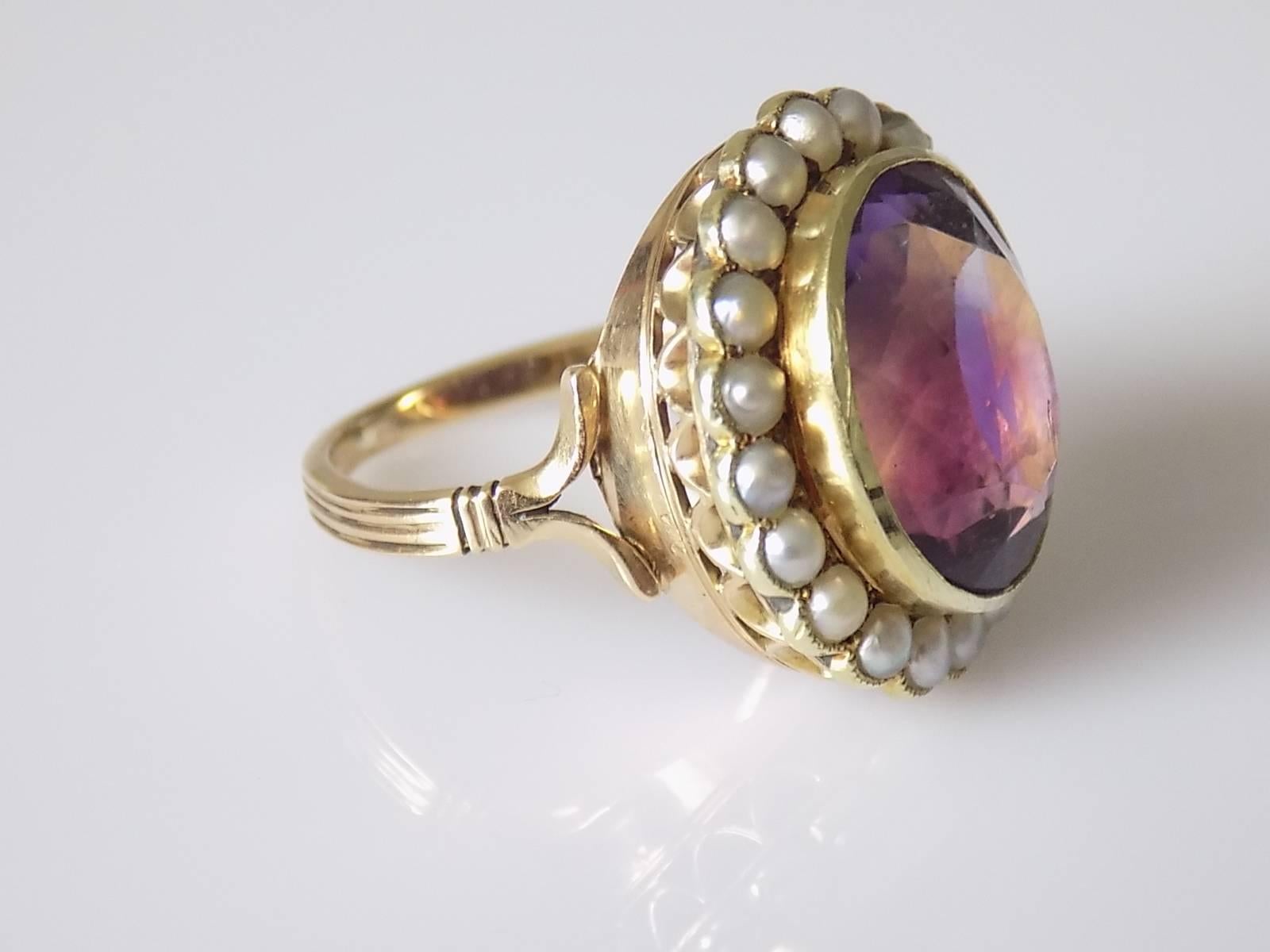 A Spectacular Victorian c.1880 15 Carat Gold, large Amethyst and split seed Pearl cluster ring. English origin.
Size M 1/2 UK, 6.75 US.
Height of the face 20mm.
Amethyst approx. 15mm x 12mm.
Weight 6.3gr.
Marked: JFB or JEB - maker, 15CT for 15