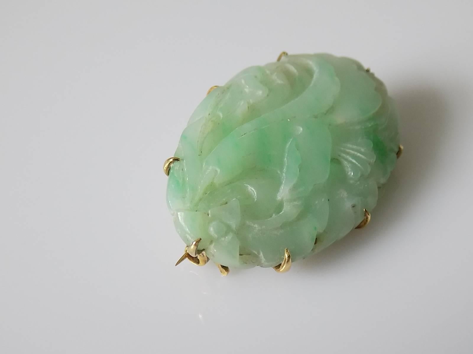 An Art Deco c.1920s beautifully carved Jadeite Jade with a flowers and foliage design brooch in 15 Carat Gold setting. English origin.
Length 39mm, Width 26mm.
Weight 11.6gr.
Marked 15CT for 15 Carat Gold.