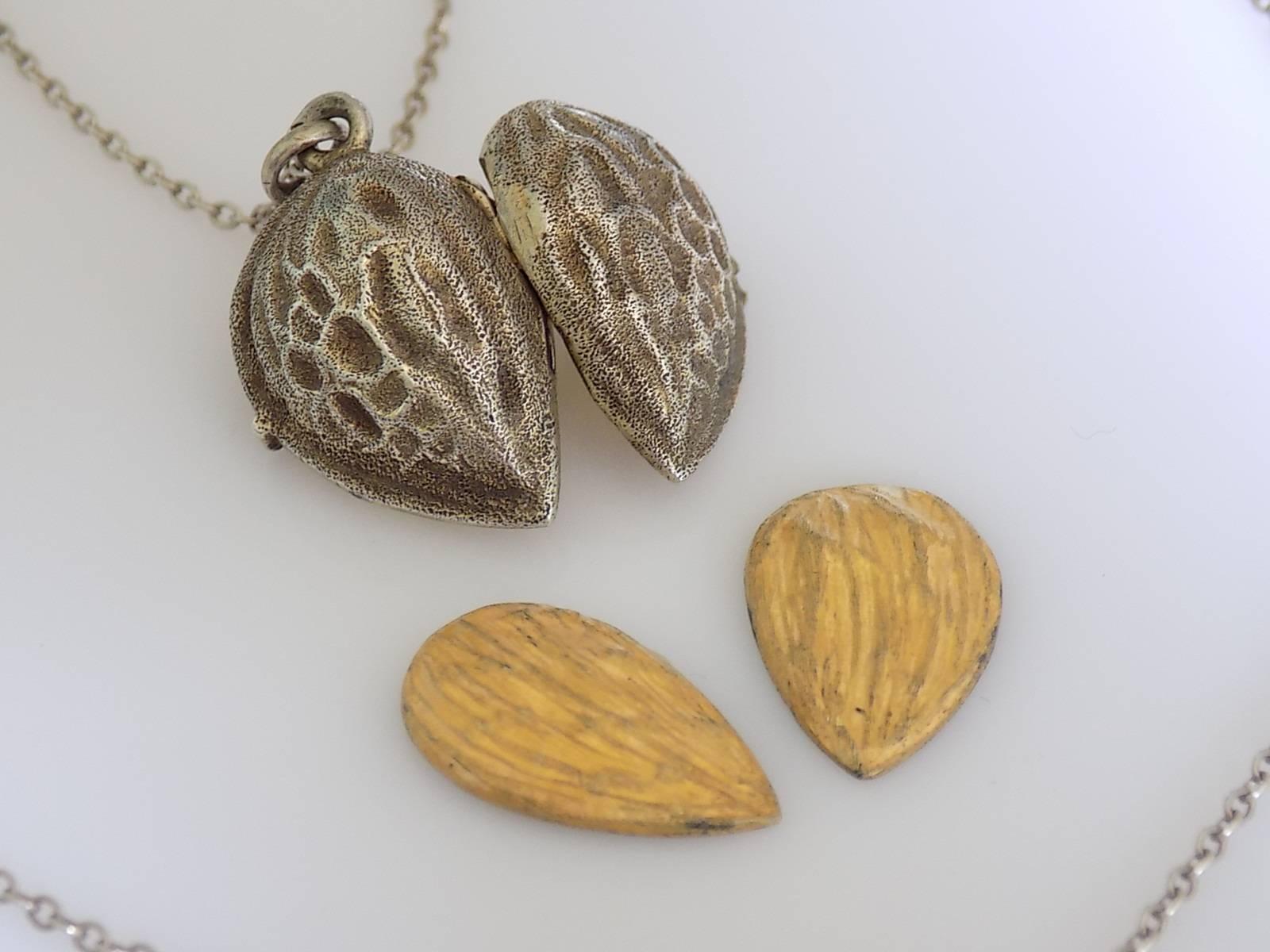 A Lovely late Victorian solid Silver and Gilt Almond locket. The locket complete with a realistic painted nut inside and Silver chain (tested). Beautiful details all the way around. Possibly French origin.
Total drop including top ring 26mm, width