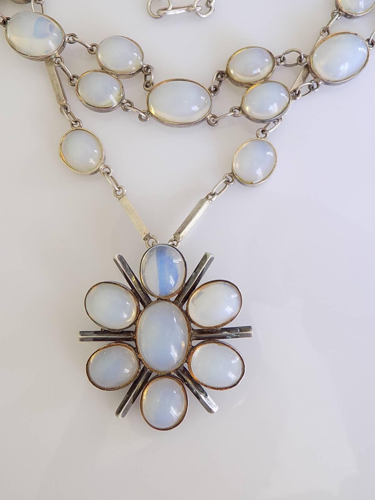 A Stunning Art Deco c.1920s/30s Sterling Silver set with a Moonstone paste also known as Opaline glass. 
The set included:
Necklace 18 1/2" including clasp;
All in One brooch/pendant width 42mm;
Bracelet 7 1/2";
Screw back drop earrings,