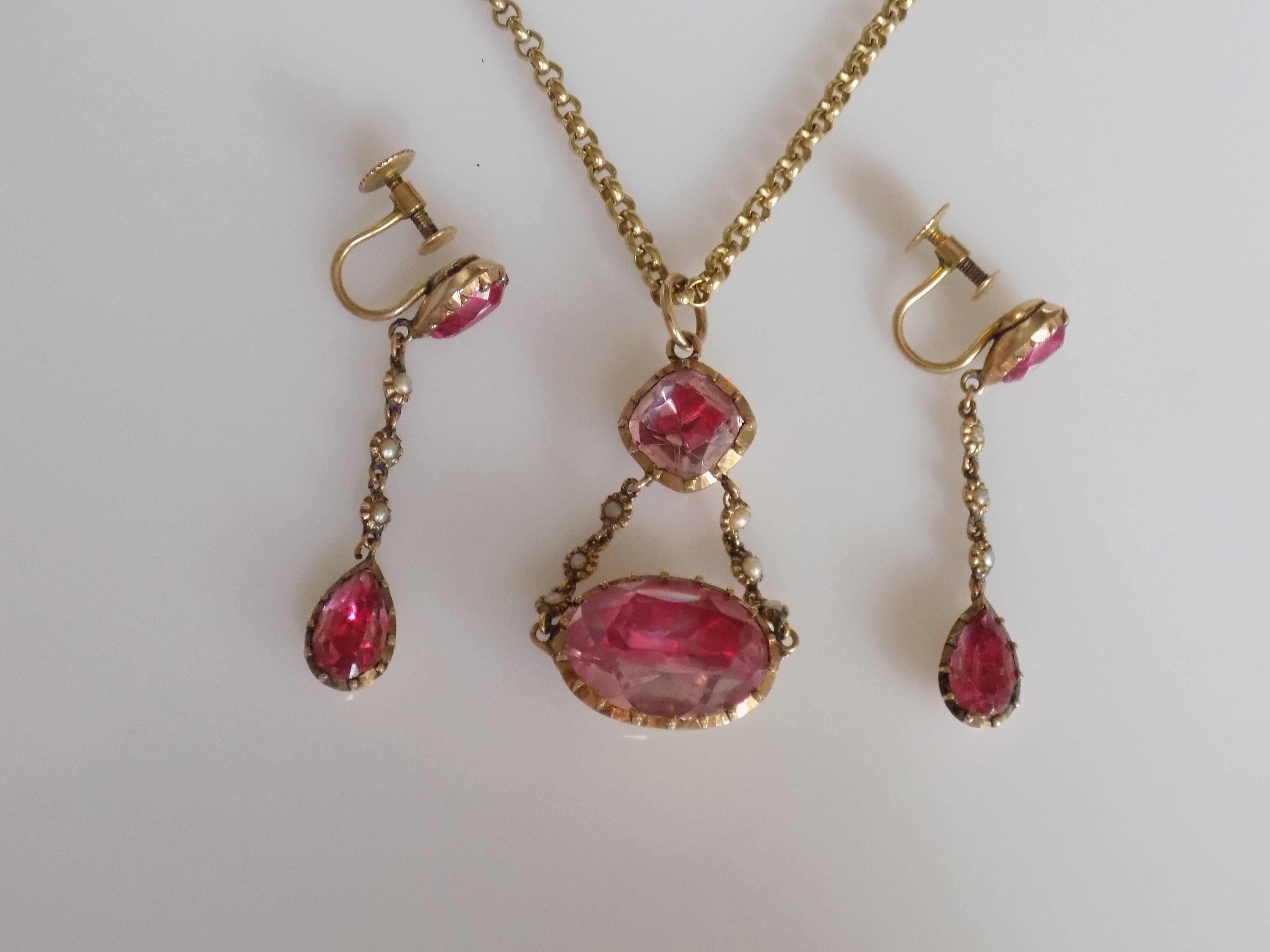 A Gorgeous Georgian c.1830 Pink Topaz paste (glass) and Natural split seed Pearl set . The stones in a foil backed Gold setting. The pendant complete with a modern 9 carat Gold Belcher chain. the earrings complete with a screw back fittings. An